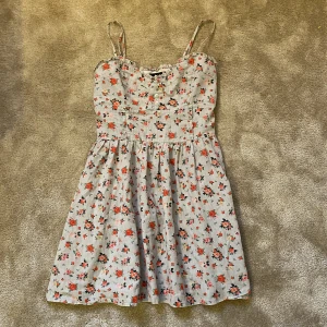 Klänning  - Blå klänning med röda och rosa blommmor på. Regleringsbara axel band🩵🩷❤️💚