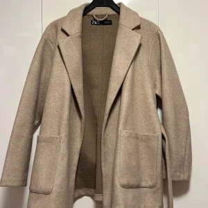 Beige kappa  -  Beige kappa köpt från Zara, storlek 38 men jag är en 36 och den satt perfekt på!