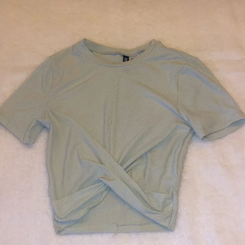 En ljusgrön croppad t-shirt med en detalj i fram. Väldigt bekväm och tunn tröja i storlek XS, från Divided by H&M. T-shirts.
