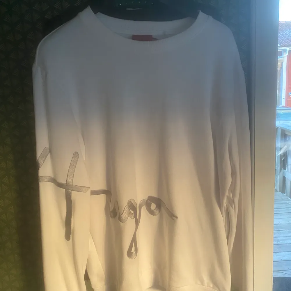 En skön hugoboss tröja storlek L helt oanvänd och ny. En vit färg och en silvrig text som verkligen gör outfiten. Nypris 1300. Tröjor & Koftor.