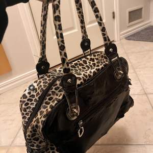 En leopard handväska med silver detaljer, har ganska mycket skador på utsidan på en av sidorna så därför ganska billigt. Insidan är hel💞