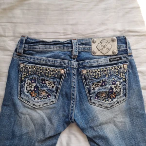 Miss Me jeans - Superfina lågmidjade jeans från Miss Me! Modellen heter skinny, men jag skulle säga att dom är lite raka. Bra skick med fina detaljer. Strl 26. Midja rakt över: 37 cm. Innerben: 78 cm. Ytter: 97 cm.