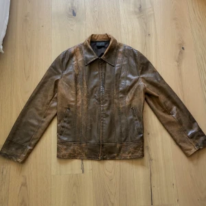Distressed brun jacka - Distressed jacka i varmbrunt konstläder. Strl XL men liten i storleken och passar lika fint på XS-L (har S i annat som referens till bilden). 