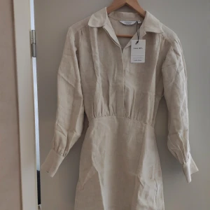 Beige klänning & OtherStories  - Helt NY! Jättefin klänning i 100% linne. "Volominous Linneklänning" från & Other Stories. Storlek 32. Säljes då jag köpte fel storlek och då jag inte hann skicka tillbaks.   Nypris: 890!