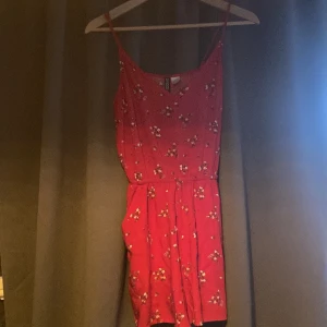 Röd linne-shorts (något ingen aning) - Röd blommig linne-shorts som sitter ihop med töjbart vid midjan jätte fint skick men passar inte mig jag tog en bild för att visa att det inte var en klänning, frakt ingår inte. Och den är bara provad en gång ^^