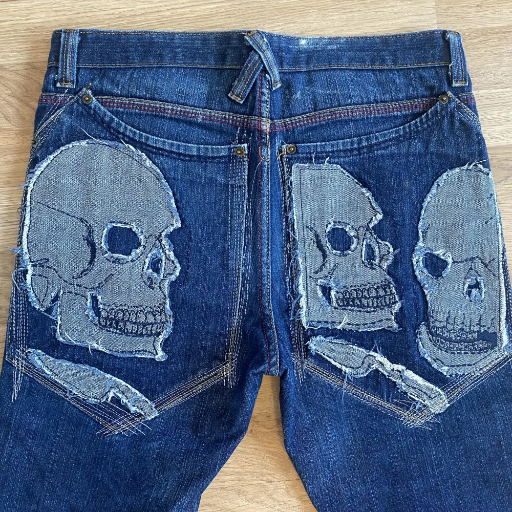 Ascoola jeans från artful dodger med dödskallar bakpå. Bra skick! De passar tyvärr inte mig så säljer därför. Jeans & Byxor.