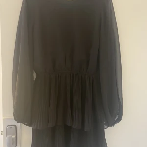 Klänning  - Svart klänning med volang