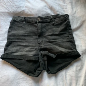 Svarta/gråa jeans shorts - Ett par svarta/gråa jeans short med två fickor där bak och då fickor ifram, kommer ifrån H&M och köpte för kanske 2 år sen, men är väldigt bra kvalitet så det är hela och fina, tvättas innan av skickning!