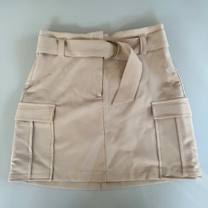 Cargokjol - Cargokjol från Gina Tricot, köpt för ca 2-3 år sen. Aldrig använd, väldigt fint skick. De silvriga spännena har tappat lite färg, men syns knappt när bältet är snörat. Storlek 38 🤍