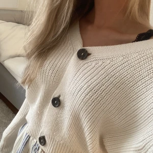 Vit stickad kofta! - Koftan är V-ringad och går att använda både öppen eller stängd. Storlek 32/34 eller uppskattat XS/S.  Perfekt att bära över en klänning och har inga defekter!💕Köparen står för frakt!