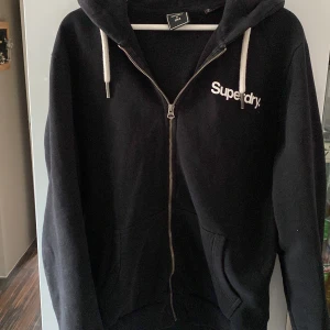 Superdry zip hoodie - Säljer en fet zip hoodie från superdry eftersom att jag rensar garderoben och den kommer inte till användning. Jättebra skick och stilren. Köpt för 800