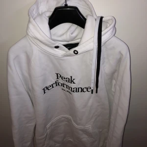 Peak Performance hoodie - Peak Performance hoodie i nyskick Nypris: 1000kr Medföljer svart och vitt snöre till huvan (se bild)      Storlek M    OBS!! En ytterst liten fläck under märket på framsidan (därav priset) går bort om man vill.  Hör av dig vid frågor!