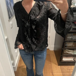 Svart topp - As cool tröja med fina detaljer. Passar till allt! Använt ett fåtal gånger därmed bra skick. Storlek L på tröjan men skulle säga att den sitter som en S. Köparen står för frakt.