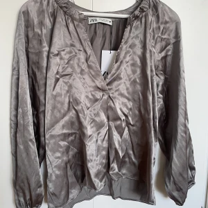 Grön blus - Gröngrå blus från zara, finns en knapp vid halsen man kan knäppa. aldrig använd