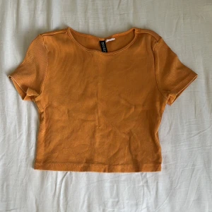 Topp - Säljer en kort topp från h&m. Den är orange och ribbad. 