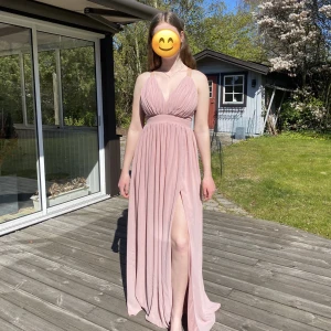Balklänning - Rosa balklänning med slits vid vänstra benet, dragkedja i ryggen, från Bubbleroom, den har några fläckar på högra bröstet och vid midjan där tyget är veckat vilket gör att dem inte syns lika mycket, försöker mig på att sälja denna till en billig peng ändå