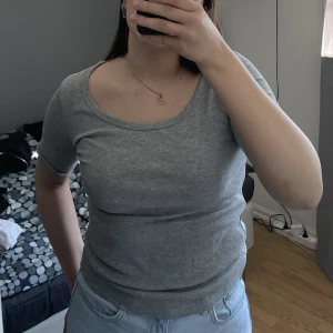 T-shirt  - En ribbade grå T-shirt från hm i storlek M. Nästintill oanvänd eftersom jag inte gillar den låga skurningen vid halsen.