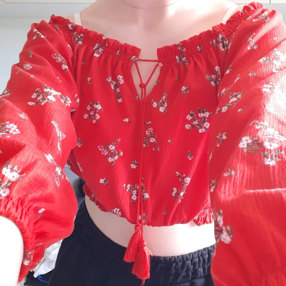 Röd blommig kort blus med knyte och lång ärm. Fin tröja nu inför sommaren. Den är använd ett fåtal gånger och nu har den inte kommit till användning på länge, just därför jag säljer den. Skriv för mer info och bilder❤🌹. Blusar.