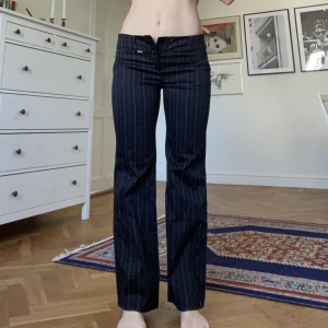 Lågmidjade pinstripe kostymbyxor  - Lowraise. Storlek M. Snygga fickor baktill. Raka i formen.  Midjemåtten: 80-85 cm  Innebenslängden: 82 cm