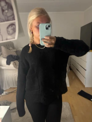 Svart stickad tröja Zara - Mysig svart stickad tröja med rund hals och en två ficka framtill från Zara