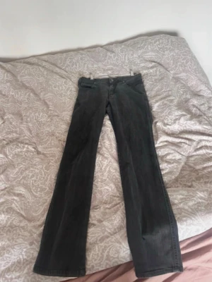vintage Armani bootcut  Jeans - Storlek S (Låg midja& bootcut) - Säljer ett par svarta vintage  bootcut jeans från märket Armani med klassisk femficksmodell och snygg AJ-detalj på bakfickan. Jeansen har låg midja och raka ben som går ut lite nedtill. Perfekta för dig som gillar en tidlös och avslappnad stil.