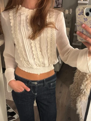 Vit blus med spetsdetaljer - Supersöt vit blus i tunn, luftig kvalitet med långa ärmar och breda spetsdetaljer framtill från h&m💕