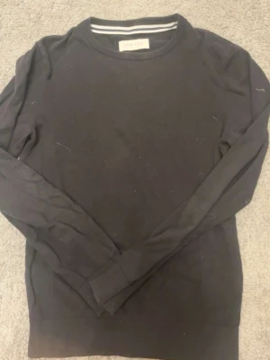 Svart basic tröja från pier one - En stilren svart långärmad tröja från pier one. Perfekt att matcha med jeans. Tillverkad i mjukt material som känns skönt mot huden. S