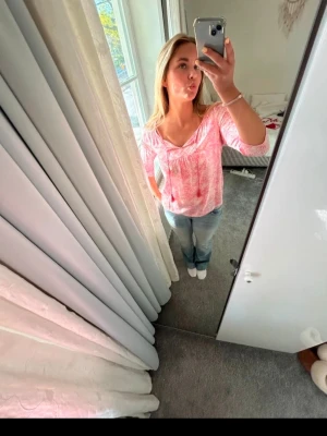 Rosa blus - Säljer en söt blus i rosa och vitt med v-ringad hals och trekvartsärm. Ena toffsen har lossnat på ena sidan, men snöret är fortfarande kvar.