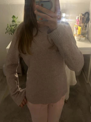 Rosa stickad tröja - Mysig rosa stickad tröja med rund halsringning och långa ärmar. Tröjan har en enkel och stilren design utan mönster och är tillverkad i ett mjukt, tunt stickat material som känns skönt mot huden. Perfekt att matcha med jeans eller mjukisbyxor.