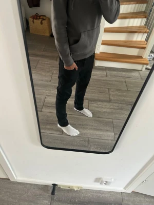 Svarta slim fit jeans från Jack and jones - Säljer ett par svarta slim fit jeans med klassisk femficksdesign och diskreta sömmar på bakfickan. Jeansen har normal midja och är tillverkade i ett mjukt denimtyg med lite stretch för extra komfort.