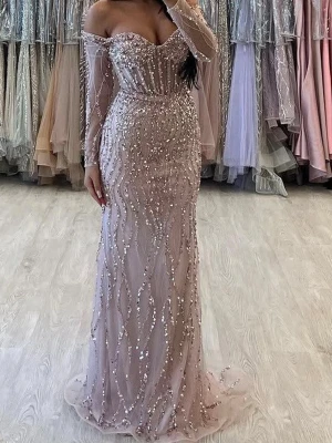 Rosa fest Lång glittrig offshoulder klänning - Elegant långklänning i ljusrosa med glittriga paljetter och offshoulder-design. Klänningen har långa ärmar i transparent material och figurnära passform. Perfekt för dig som vill sticka ut på bal eller fest.