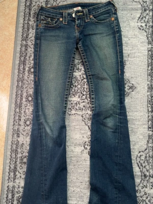 Jätte lågmidjade true religion jeans  - Jag säljer ett par true religion jeans i storlek 25 som tyvärr är förkorta för mig. Uppsprättade längst ner för att de skulle bli längre. Börjar priset på 1000kr så skicka prisförslag!❤️