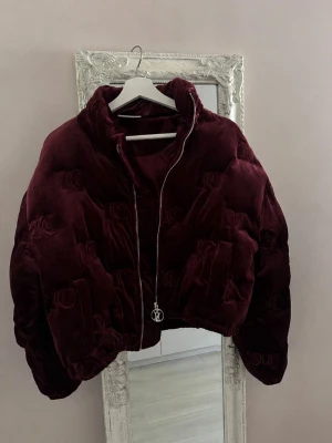 Juicy Couture vinröd velour pufferjacka Y2K – S - Vinröd Juicy Couture pufferjacka i mjuk velour/sammet ❤️ Croppad modell med quiltad design, hög krage och dragkedja framtill med Juicy Couture-logga på zip-pullern. Superfin Y2K/2000s vibe och jättefin färg inför höst/vinter. Använd endast 1 gång och är i princip som ny. Nypris ca 3499 kr.
