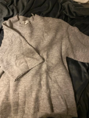 Ljusgrå stickad tröja Gina Tricot - Mysig ljusgrå stickad tröja från Gina Tricot i ullblandning.Perfekt för kyliga dagar och enkel att matcha med olika outfits.