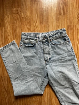 Never Denim ljusblå raka jeans med hög midja - Säljer ett par ljusblå jeans med klassisk femficksmodell och hög midja från BikBok. Jeansen har raka ben och är tillverkade i ett kraftigt denimtyg. Storleken är 25, så skulle säga xs.  