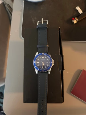 Blå klocka från Skyline med silikonband - Snygg klocka från Skyline med blå urtavla och matchande blå silikonband. Klockan har silverfärgade detaljer, tydliga markeringar och datumvisning. Perfekt accessoar för dig som vill ha en sportig och stilren look.