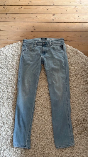Replay ANBASS slim - Snygga ljusblå jeans med raka ben och klassisk femficksdesign. Jeansen har en enkel look med diskreta sömmar och knappgylf. Perfekta för en avslappnad stil och passar till det mesta. Tillverkade i mjukt denimtyg. (Skulle säga att de är stor i storlek)