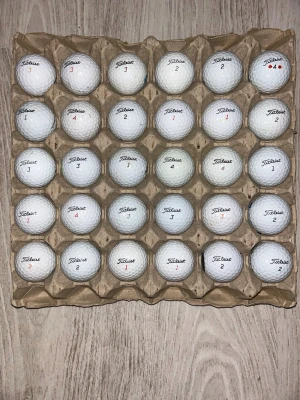 Golfbollar Titleist 30st - Säljer ett 30-pack vita golfbollar från Titleist. Bollarna har klassisk rund form och är förpackade i en äggkartongsliknande hållare. Perfekt för dig som vill fylla på golfutrustningen med kvalitetsbollar. Alla bollar är tvättade och spelas med som nya.