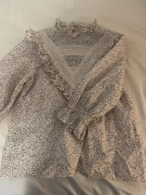En blus med volang i ärmarna från H&M - En jätte gullig blus som har volang i ärmarna från H&M. Jätte fint att ha på sommaren t.ex på midsommar. Passar perfekt till en kjol/jeans kjol.
