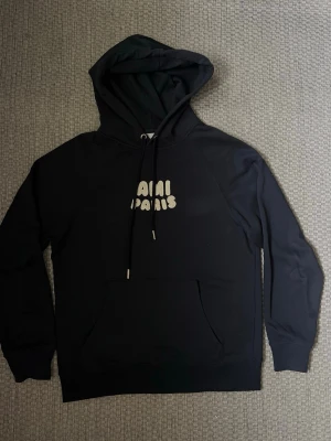 Mörkblå hoodie från Ami Paris - Mörkblå hoodie  från AMI PARIS med broderad vit text på bröstet. Den är storlek L men passar som M. 
