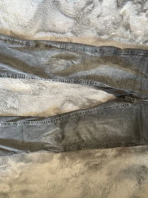Grå jeans från Gina Tricot - Snygga grå jeans från Gina Tricot i storlek 164. Modellen har smal passform med klassiska fem fickor och knappgylf. Jeansen är tillverkade i ett mjukt denimtyg som ger en bekväm känsla och passar perfekt till en avslappnad stil. Använda 2 ggr