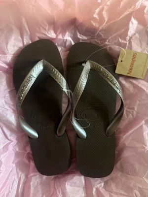 Bruna flip-flops från Havaianas - Snygga bruna populära flip-flops från Havaianas. Storlek 41-42! Helt oanvända och nya, plasten och lappen är kvar! Slutsålda överallt!