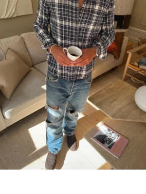 Blå flanellskjorta  - Säljer en blåvit rutig skjorta med klassisk krage och knappar framtill. Skjortan har lång ärm och normal passform, tillverkad i mjuk bomull som är skön att bära. Perfekt för dig som gillar en avslappnad men ändå stilren look. Modellen är 181cm och 73kg som referens. 