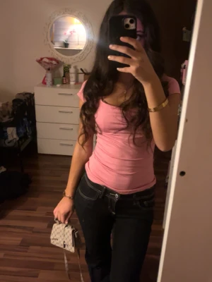 Rosa tight topp med kort ärm - Säljer en söt rosa topp med tight passform och korta ärmar. Toppen har en rundad halsringning och är gjord i ett stretchigt material som sitter snyggt på kroppen. Perfekt att matcha med jeans eller kjol för en trendig look.