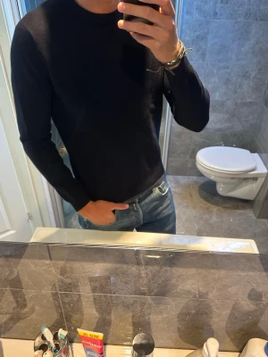 Marinblå stickad tröja  - En stilren marinblå tröja med rundad hals från Mango. Tröjan är i ett litet tjockar material vilket gör att passformen alltid håller och inte förändras i samband med tvätt eller liknande. Den är i riktigt bra skick trots användning. Jag på bilden är 188cm men den e för liten på mig nu. Hör av er vid fler frågor:)