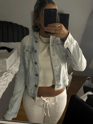 Ljusblå jeansjacka - Jeansjacka köpt secondhand i åland. den är ganska tajt på mig annars hade jag behållt😢