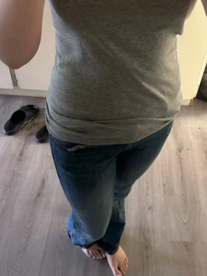 Blå bootcut jeans med fickor - Säljer ett par klassiska blå bootcut jeans med normalhög midja och snygga bakfickor. Jeansen har en tidlös tvätt och är tillverkade i ett mjukt denimtyg som sitter bekvämt. Perfekta för dig som gillar en avslappnad men ändå stilren look.