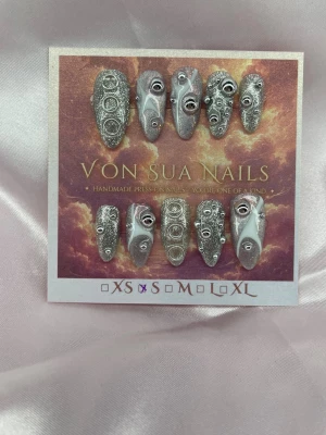 Rivet (S);Medium Almond - Handgjorda press-on nails i Medium Almond med silverglittrig bas, metalliska pärlor, ringdetaljer och vita 3D-accenter. Varje nagel har sin egen design för ett futuristiskt, industriellt uttryck.  Storlek: S Form: Medium Almond 10 handgjorda naglar Prep-kit medföljer.