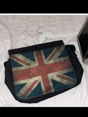 Messenger bag med Union Jack-tryck - Snygg axelväska med stort Union Jack-tryck på locket. Har justerbar rem och det får plats en laptop i. 