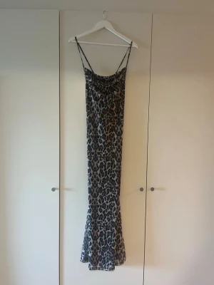Leopardmönstrad långklänning  - Leopardmönstrad långklänning i storlek S från Gina Tricot. Knytdetalj i ryggen. Oanvänd med prislapp kvar. 